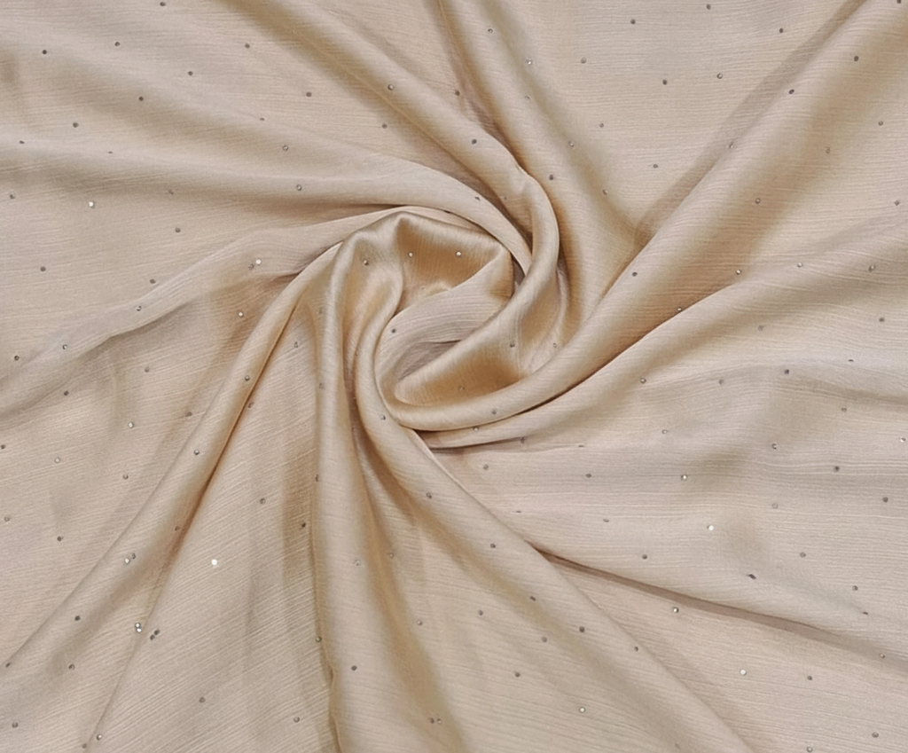 Beige fabric with small embellishments in a close-up shot