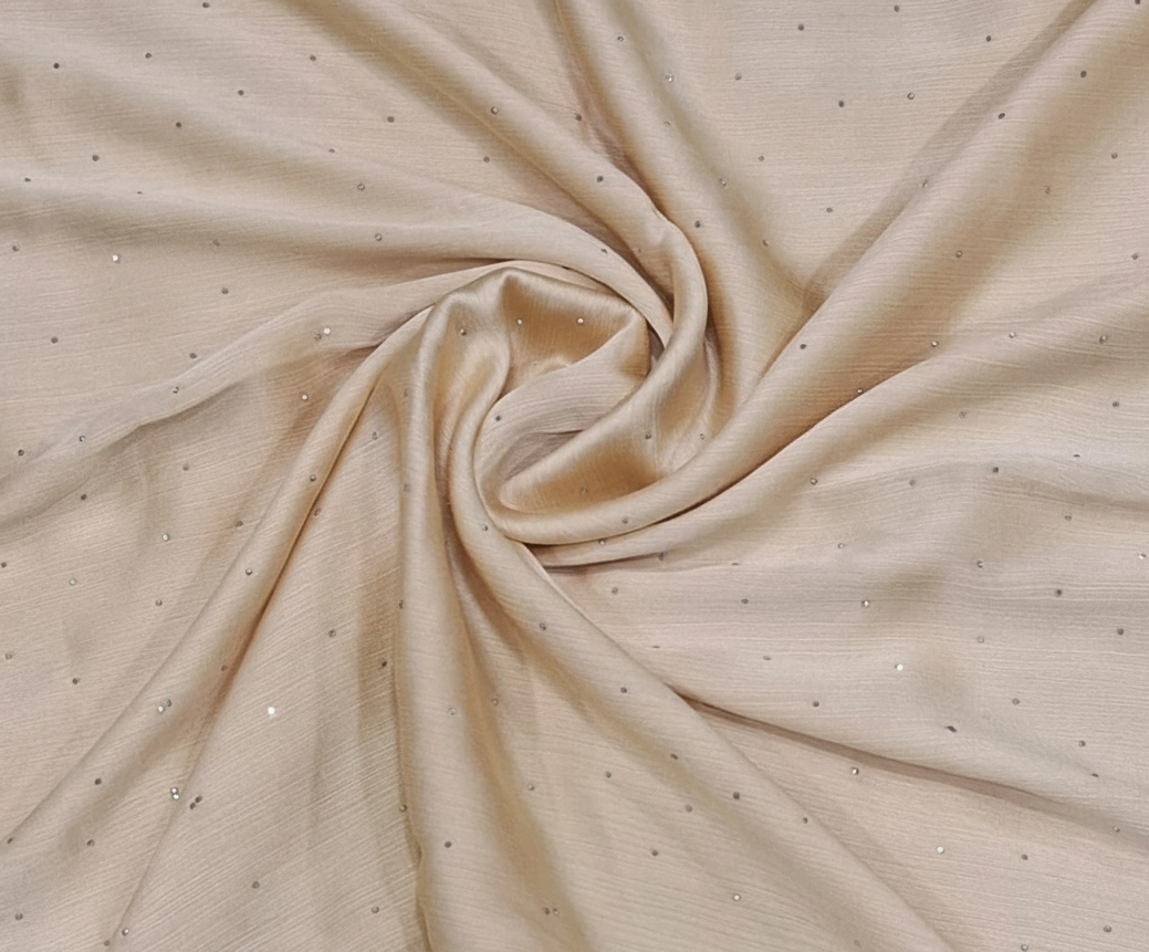 Beige fabric with small embellishments in a close-up shot